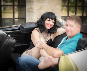 Happy couple sharing a tender moment while seated in a classic convertible car.