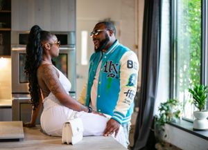 A couple shares an intimate moment together in a modern interior space wearing contrasting white and turquoise outfits.