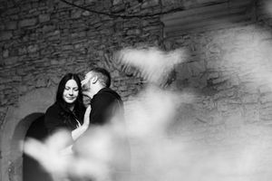 Intimate black and white portrait against a textured stone wall background.
