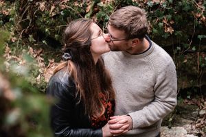 Intimate couple portrait in casual wear against natural outdoor backdrop.