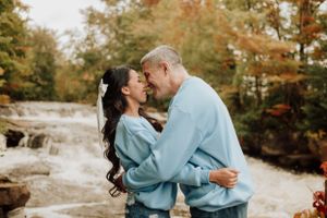 Séance photo de couple au Québec devant une chute, dans une ambiance automnale et décontractée.