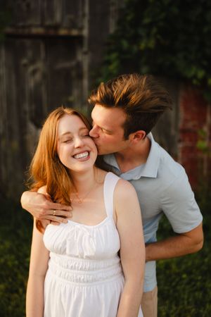 A playful couple embracing and laughing together outdoors.