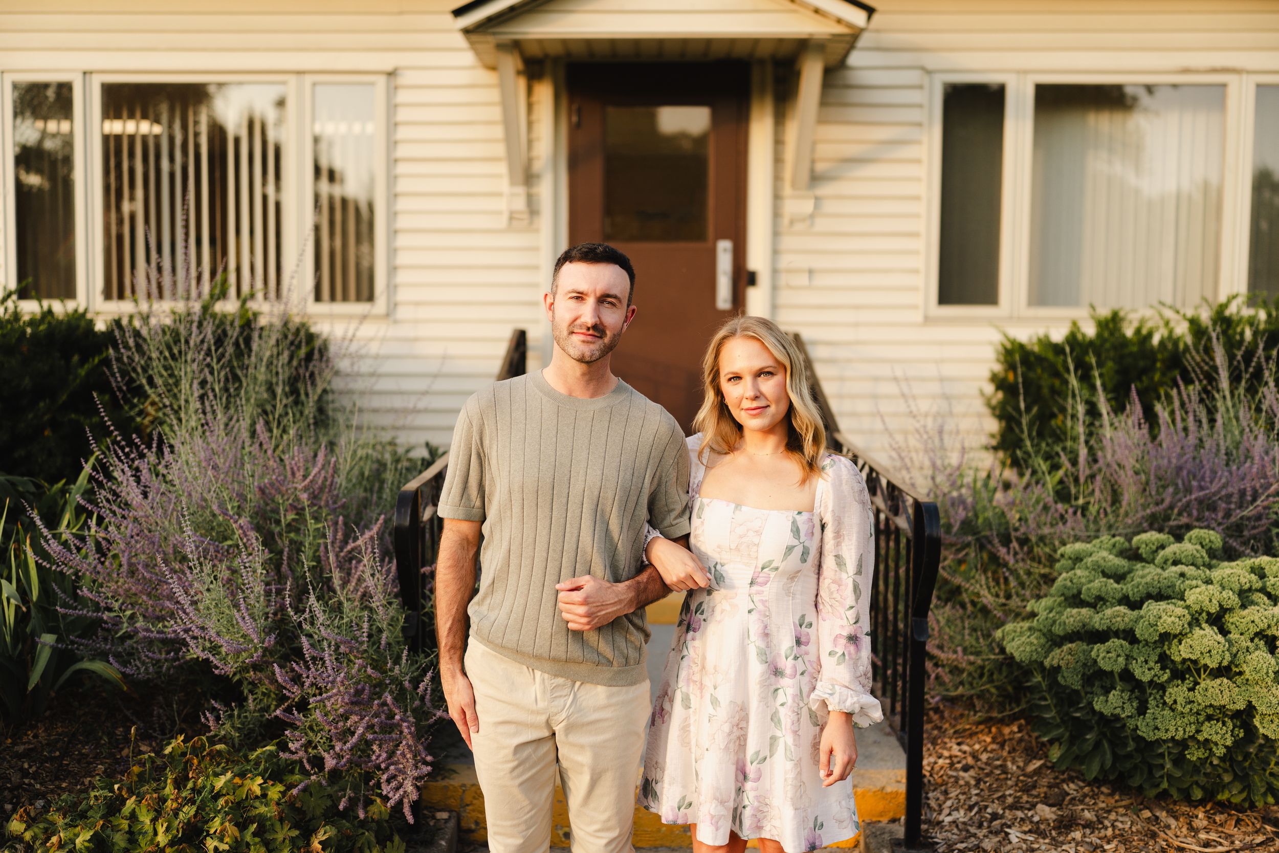 Casual outdoor portraits in front of a residential home with garden landscaping.