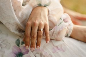 Close-up of hands showing engagement or wedding rings.