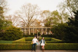 Elegant garden setting with manicured hedges and trees at sunset.