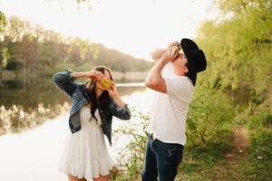 Romantic couple embraces by a serene lake during golden hour sunset.