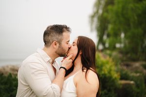A romantic moment captured between two people in a lush garden setting.