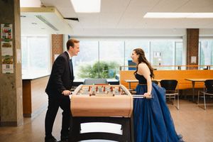 A couple dances in an indoor venue with a blue gown swirling gracefully.