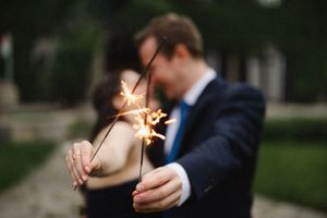 Couple holding sparklers together at dusk in an intimate moment.