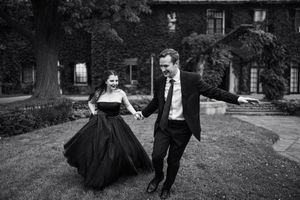 Black and white photo of couple dancing and spinning on a residential street.
