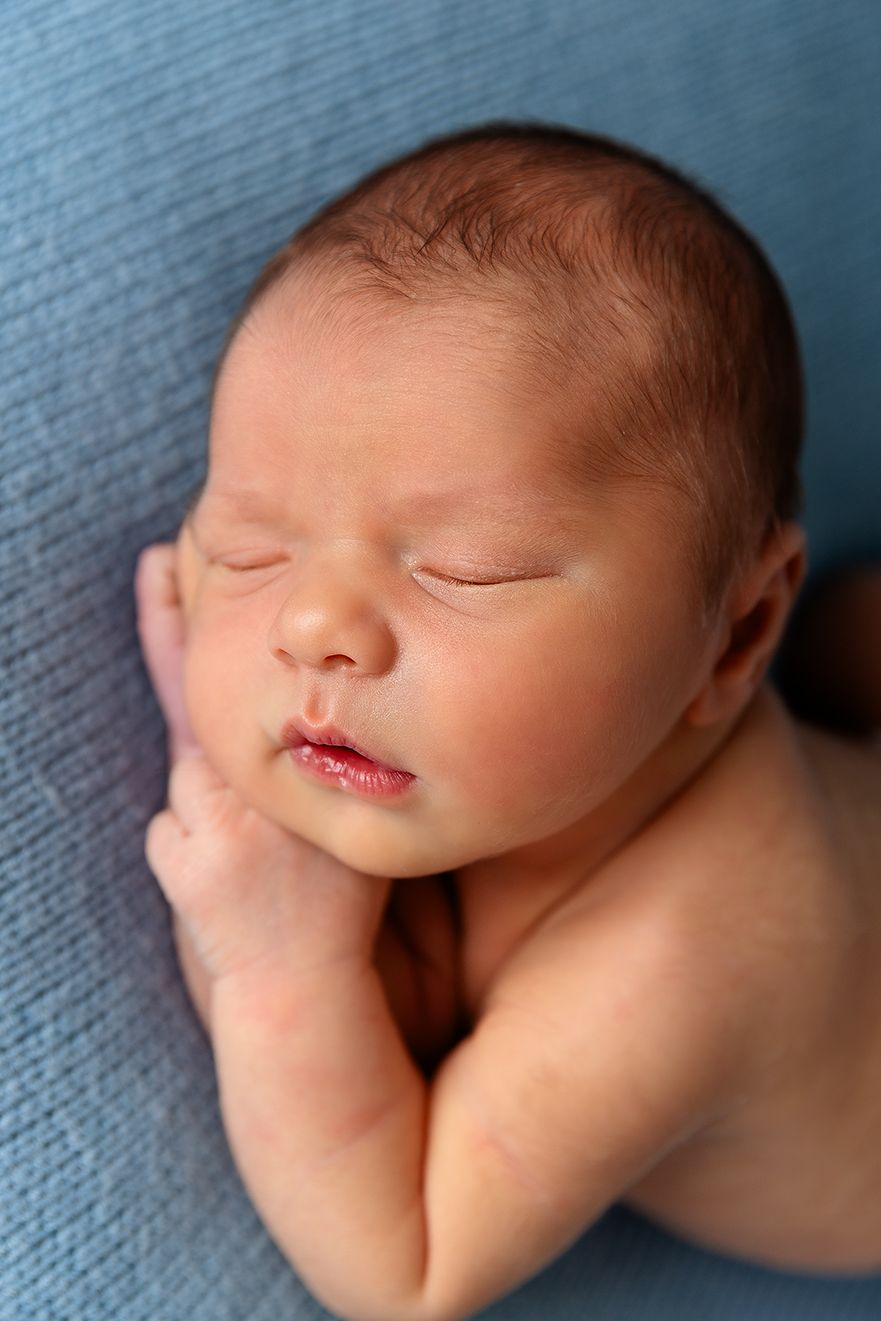 newborn-baby-side-sleeping-on-a-light-blue-blanket.jpg