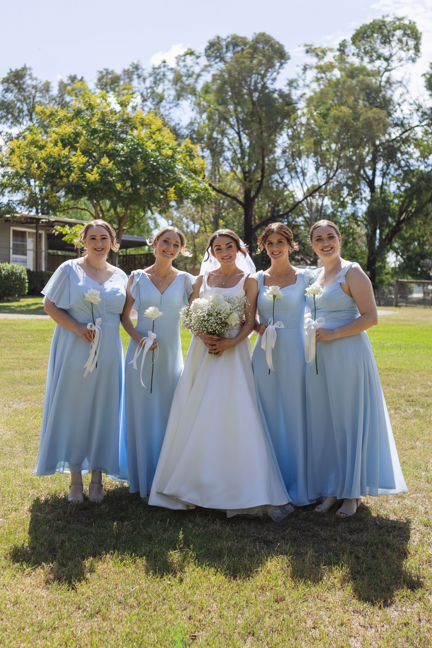 Bride and bridesmaids in blue dresses smiling at Two Rivers Winery Wedding in Denman
