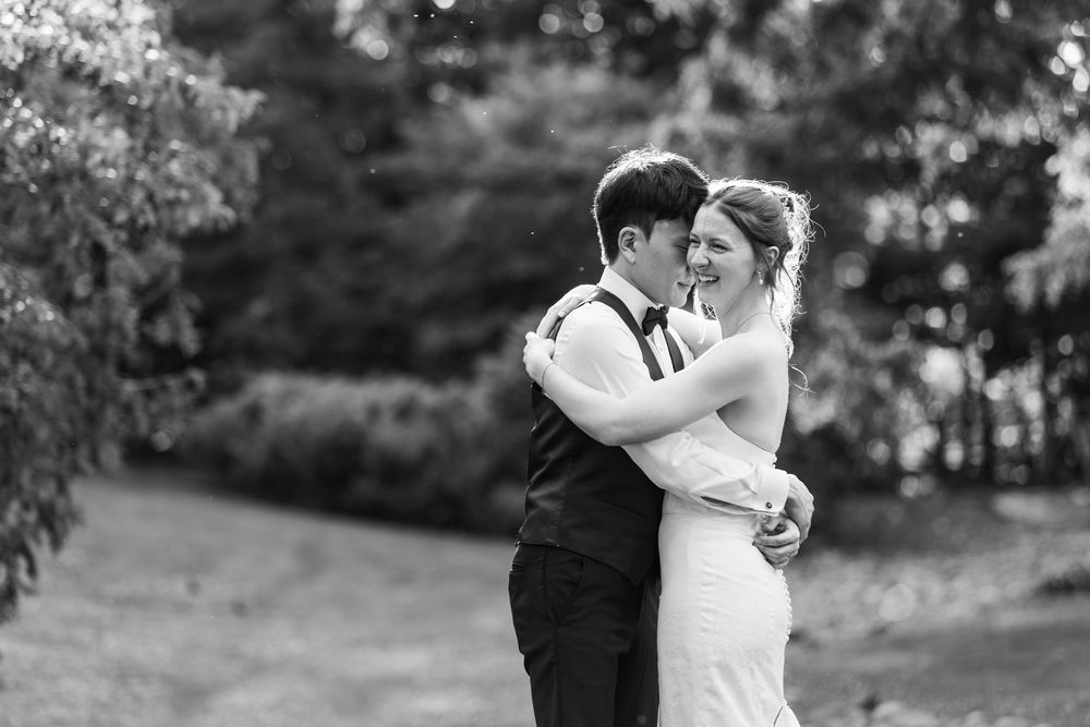 Black and white photo of a bride and groom embracing during sunset on their wedding day at the civic garden complex in london, ontario.
