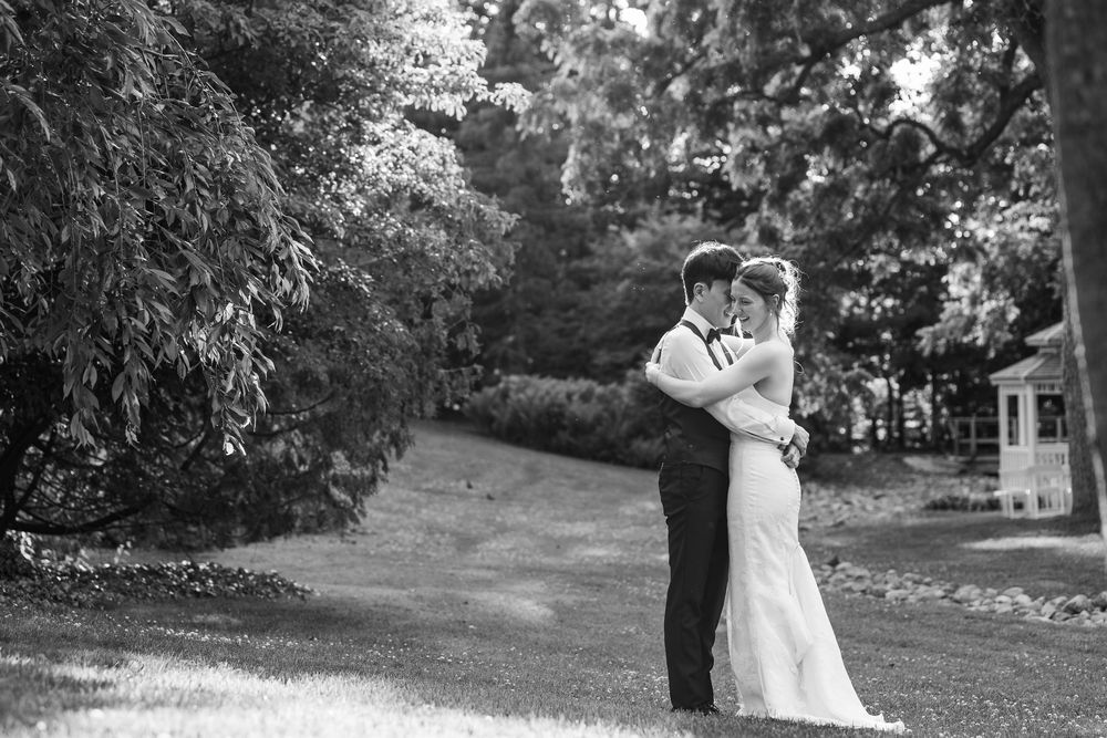 Black and white photo of a bride and groom embracing during sunset at the civic garden complex in london, ontario.