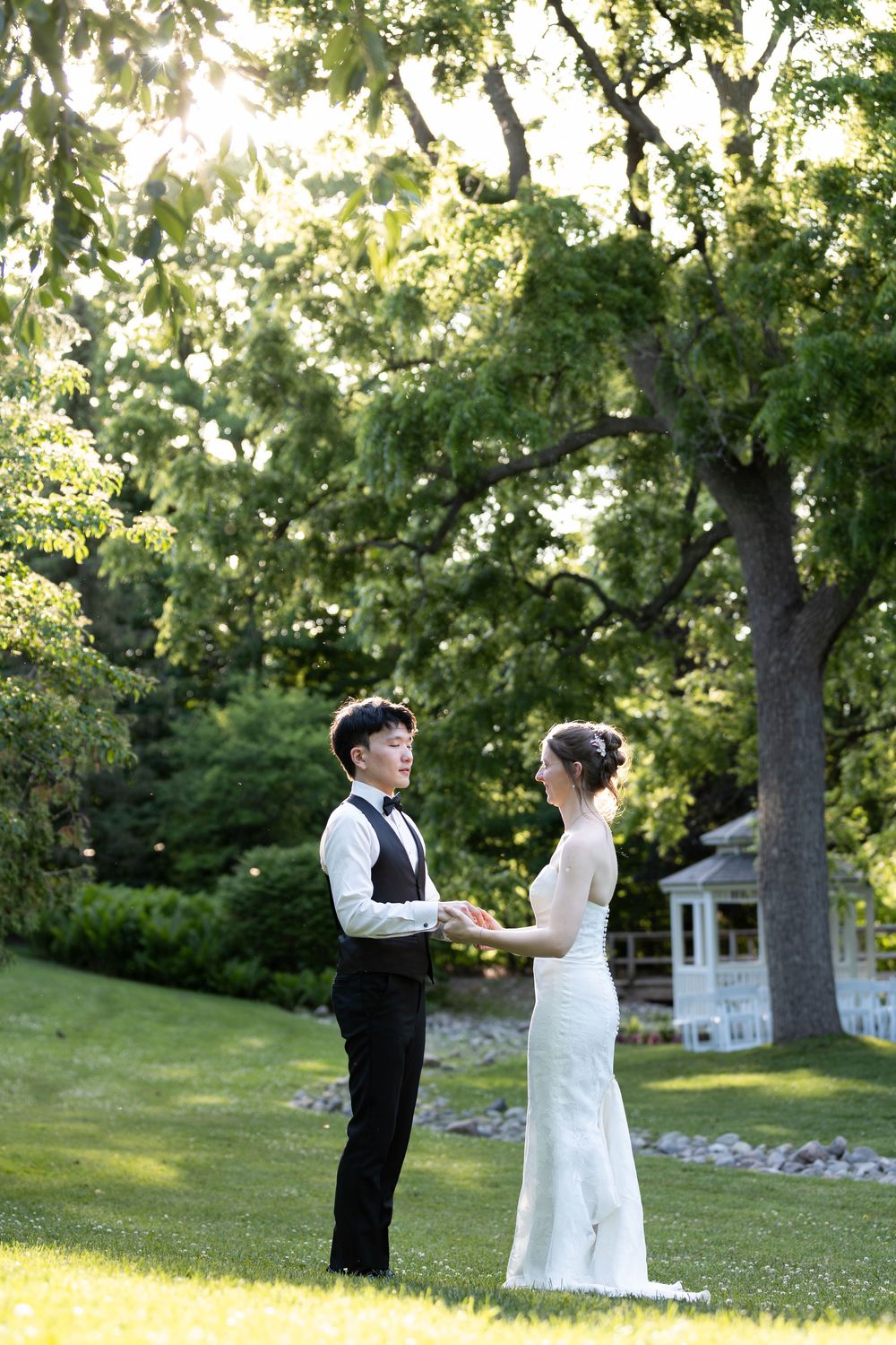 Bride & groom holding hands in a lush green garden during sunset at the civic garden complex in london, ontario.