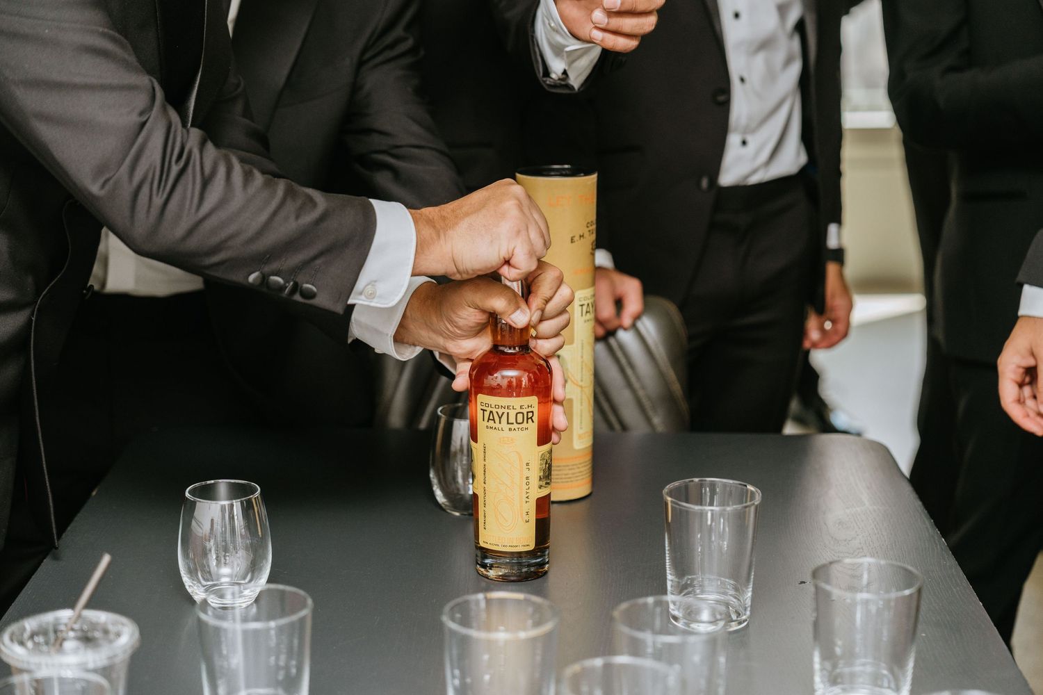 Groom pouring whiskey for a pre-ceremony toast with the groomsmen.