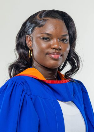 Young woman in blue and orange graduation gown smiling for a portrait photo.