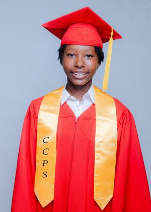 Student in red graduation cap and gown with gold CCPS stole smiling for official graduation portrait.