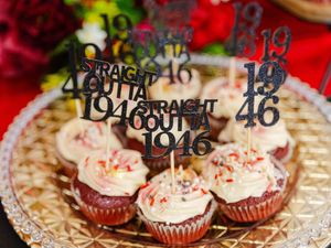 Cupcakes with Straight Outta 1946 toppers on a decorative gold plate.