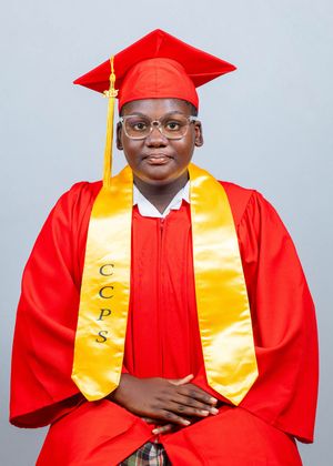 Young graduate in red cap and gown with gold CCPS stole smiles for official portrait photo.
