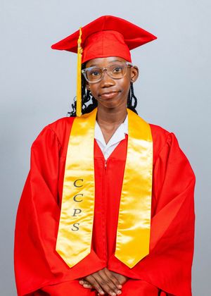 Young graduate in red cap and gown with gold CCPS stole smiling for official graduation portrait.