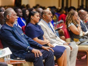 Audience members in formal attire seated attentively at an academic graduation ceremony.