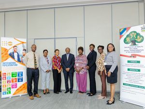 Group of professionals posing together at a health and wellness conference with promotional banners in the background.