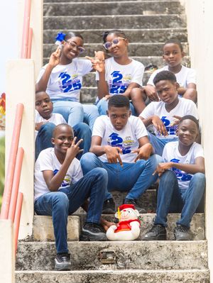 Students in matching 2025 shirts pose on outdoor steps celebrating their graduation milestone.