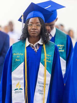 Student in blue graduation cap and gown with Seventh-day Adventist stole at Secondary School Class of 2025 ceremony.