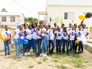 Group of students in matching Class of 2025 shirts celebrate outdoors with balloons.