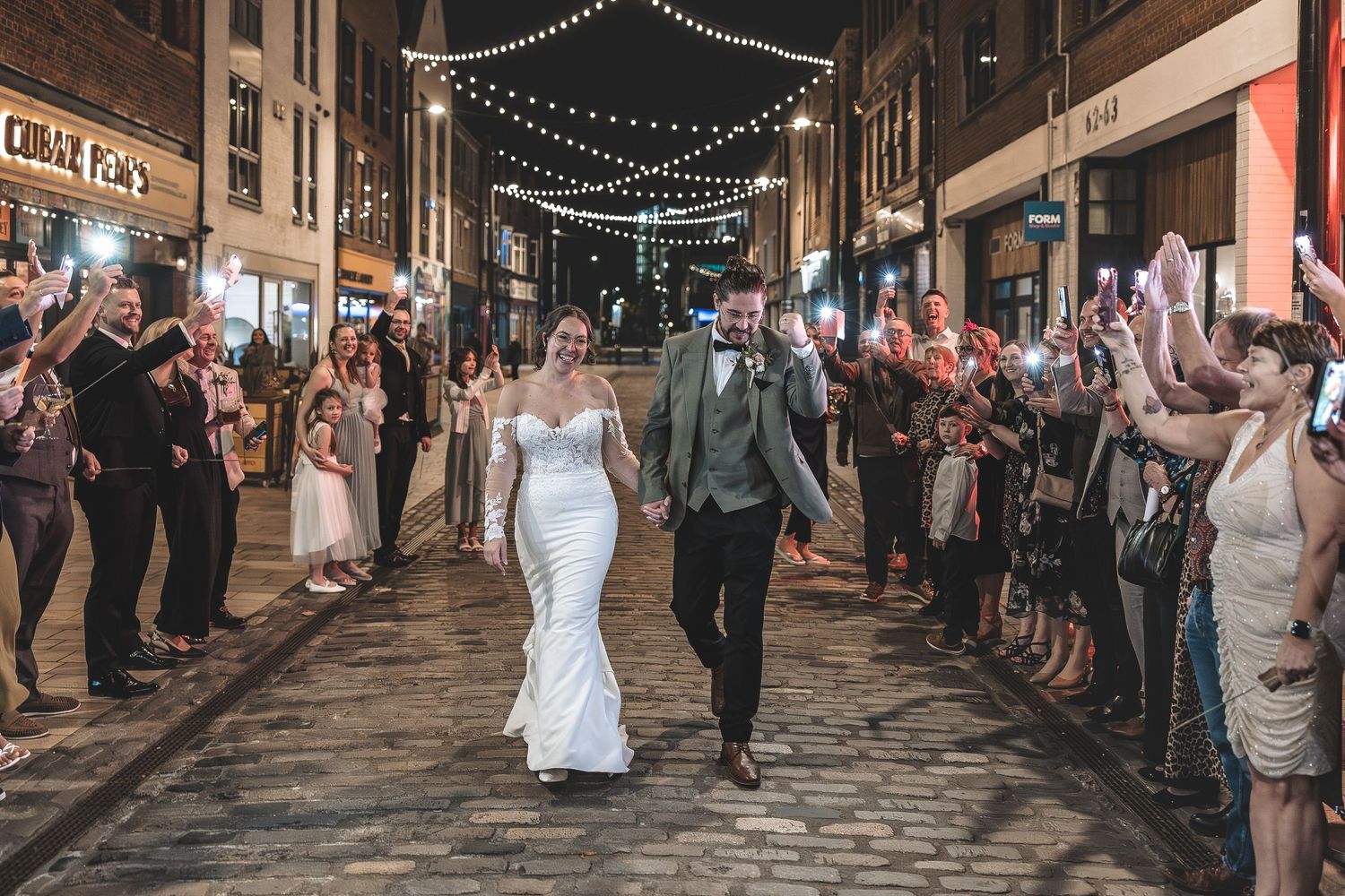Guests celebrating with married couple walking through Hull's Humber Street