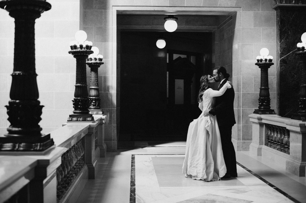 Couple sharing first kiss in stunning black and white wedding photo.