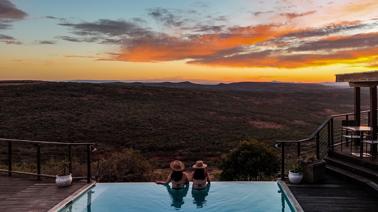 Luxury lodge with an infinity pool overlooking the African wilderness at sunrise, capturing exclusive safari and boutique travel experiences