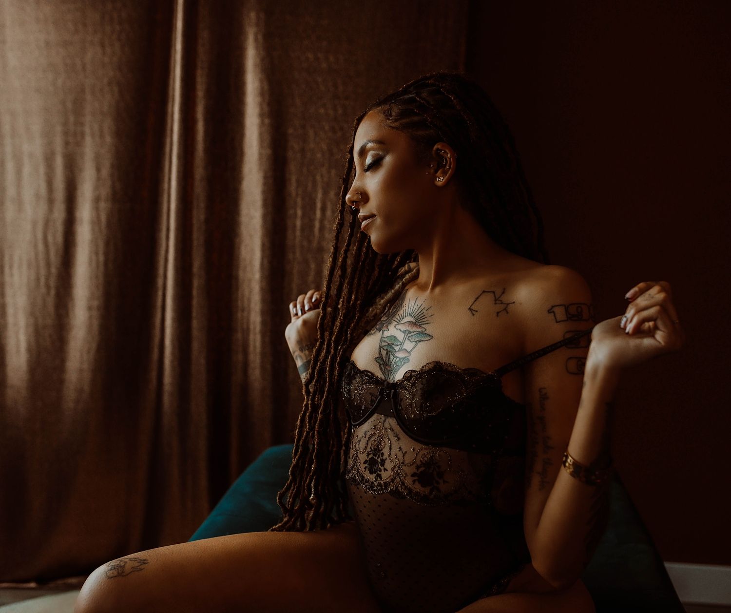 person with braids and tattoos wearing lingerie in studio by Wisconsin portrait photographer