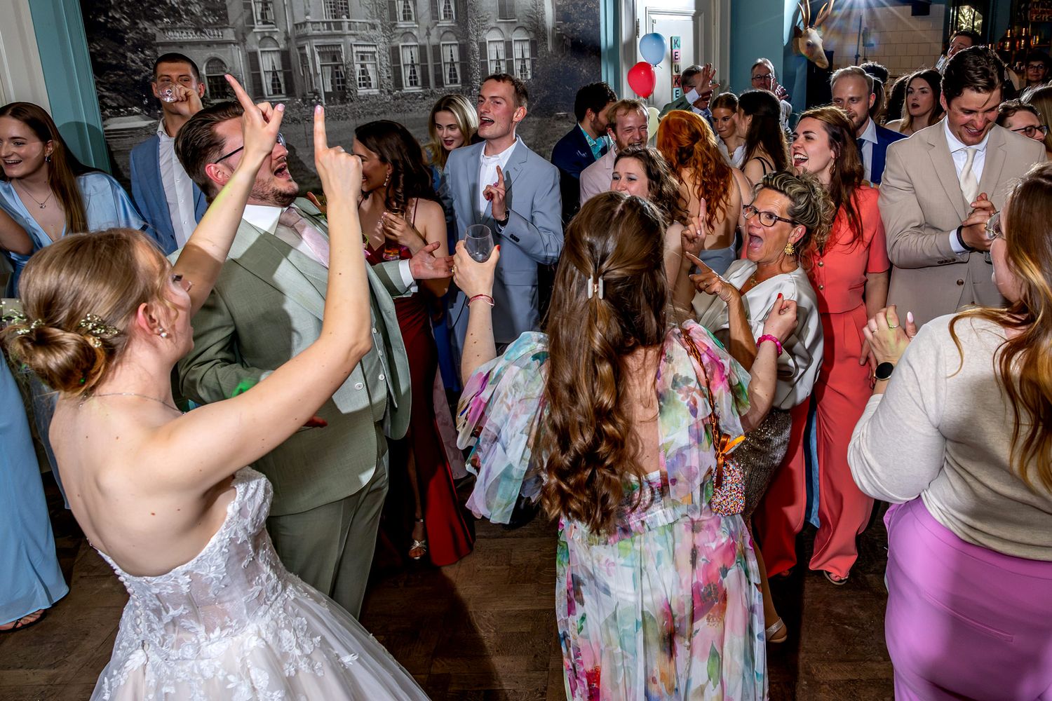 Bruid Donna met haar handen in de lucht op de dansvloer tijdens het feest bij De Smaeckkamer in Beverwijk
