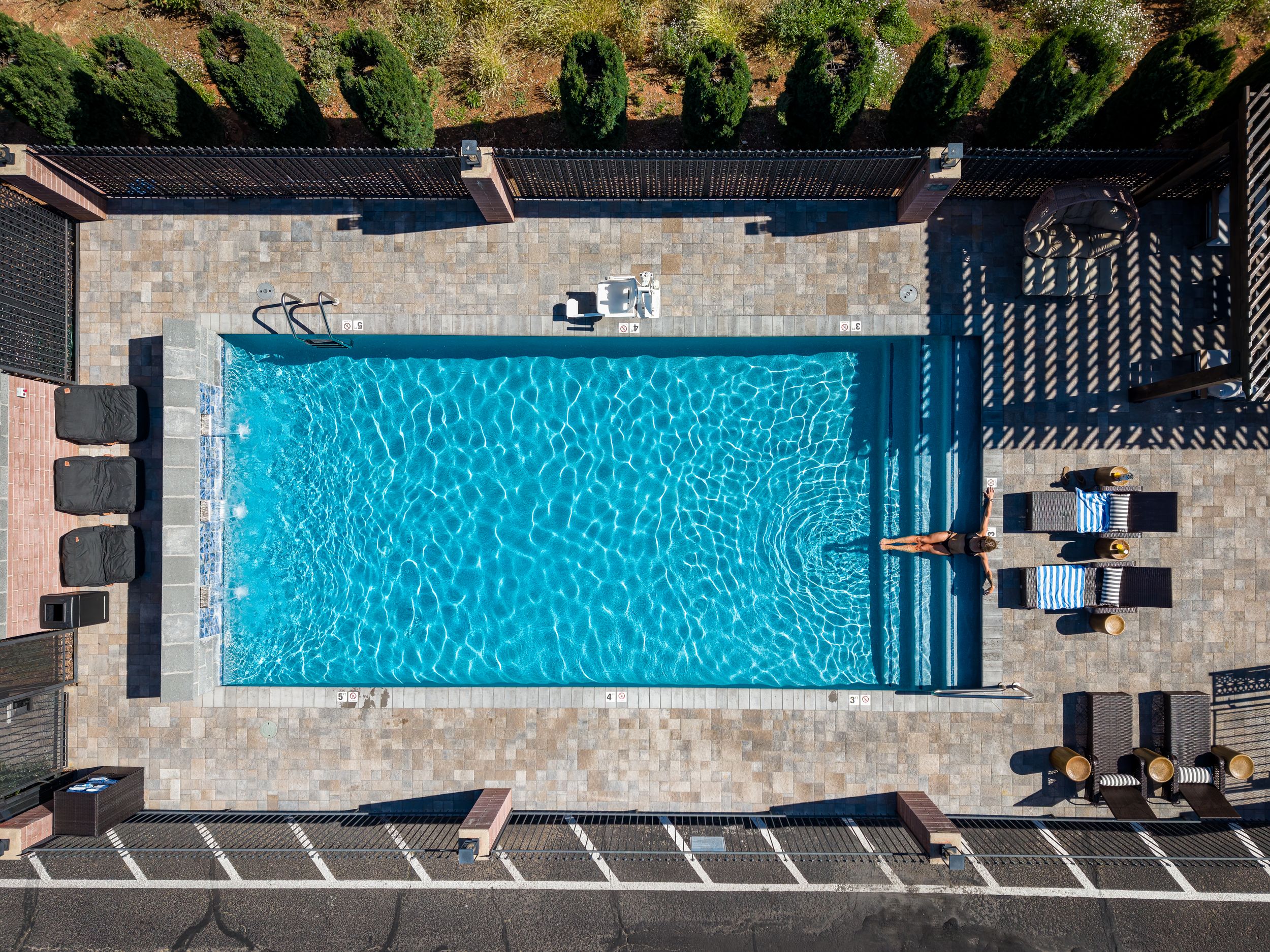 Aerial top down shot of a woman relaxing in the pool at a luxury hotel, The Kokopelli Inn in Sedona, AZ.