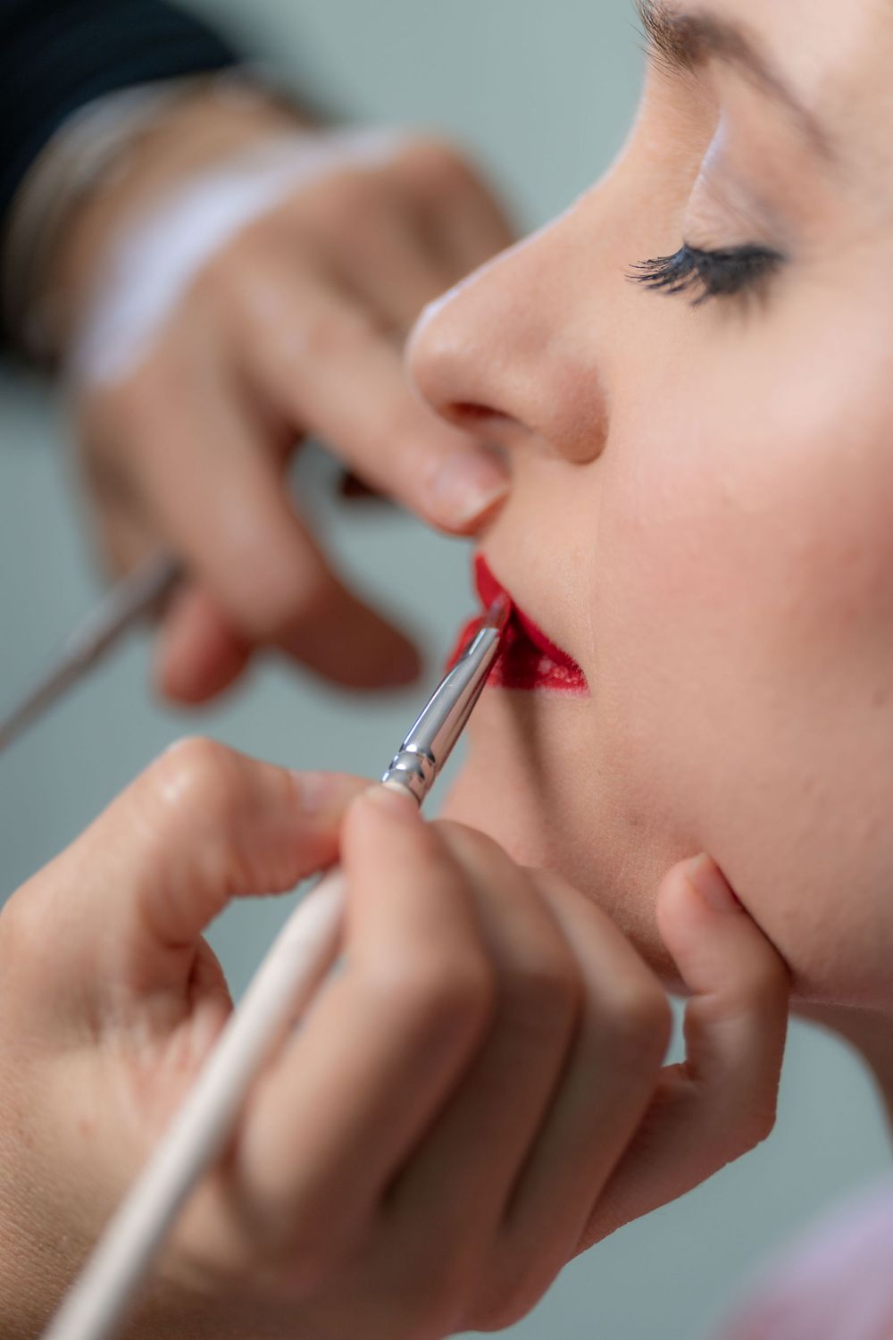 Makeup artist applying red lipstick to a bride at the Wyndham Grand, Jupiter, FL