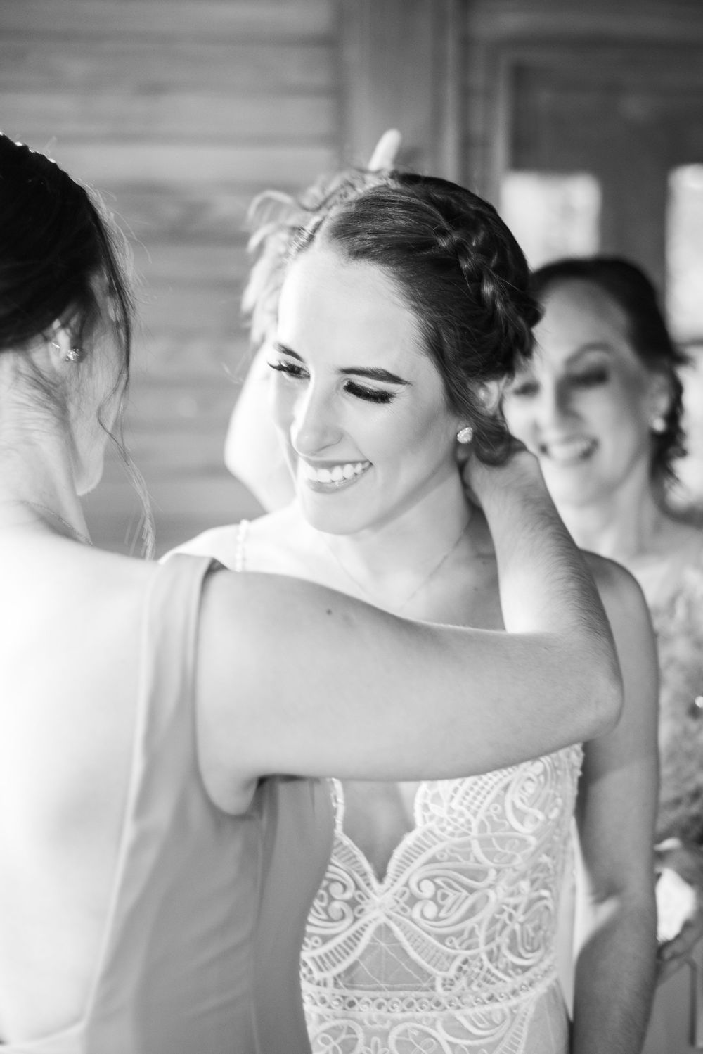 Novia poniéndose collar en el día de su boda
