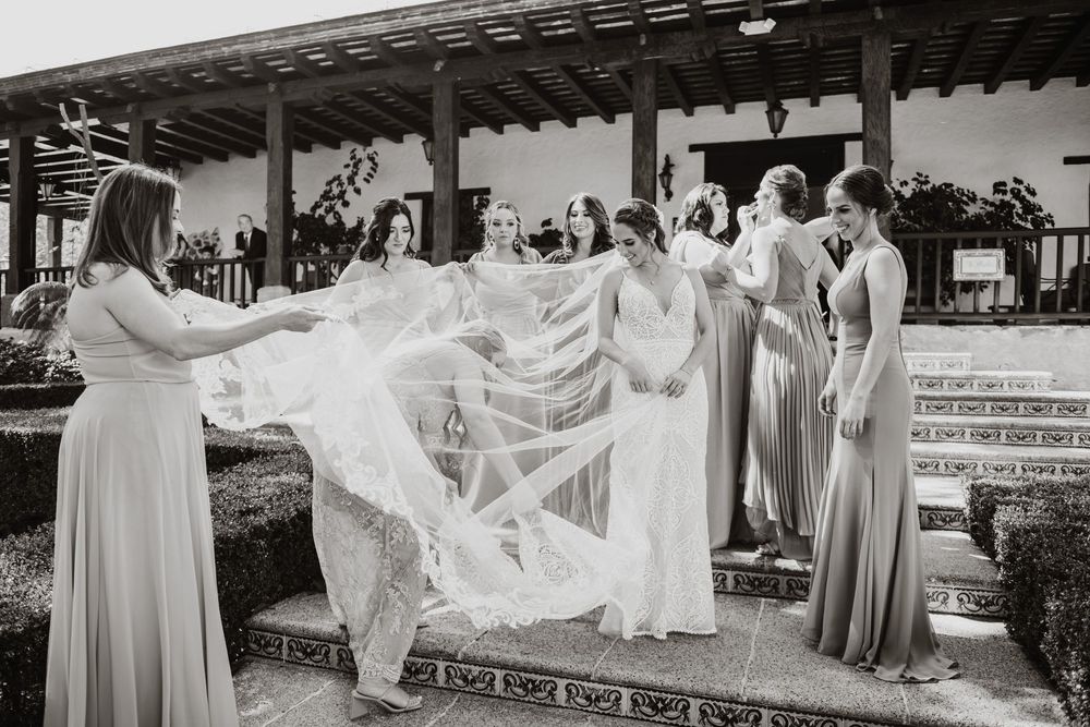 Novia con damas y velo en sesión de jardín