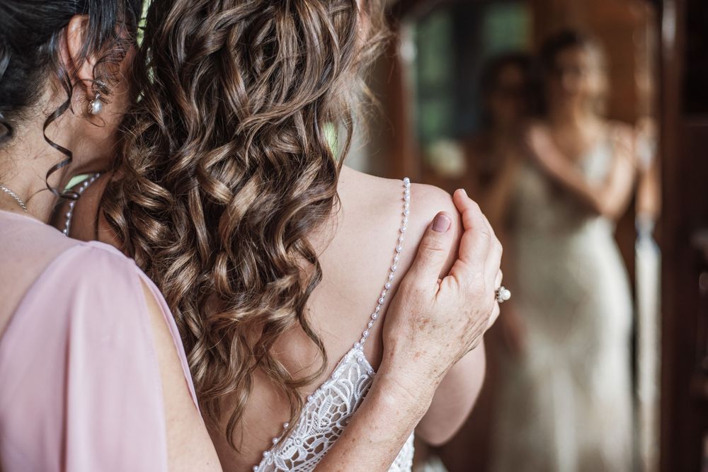 Detalle de mano de Mamá de la novia y novia en el espejo en el día de la boda