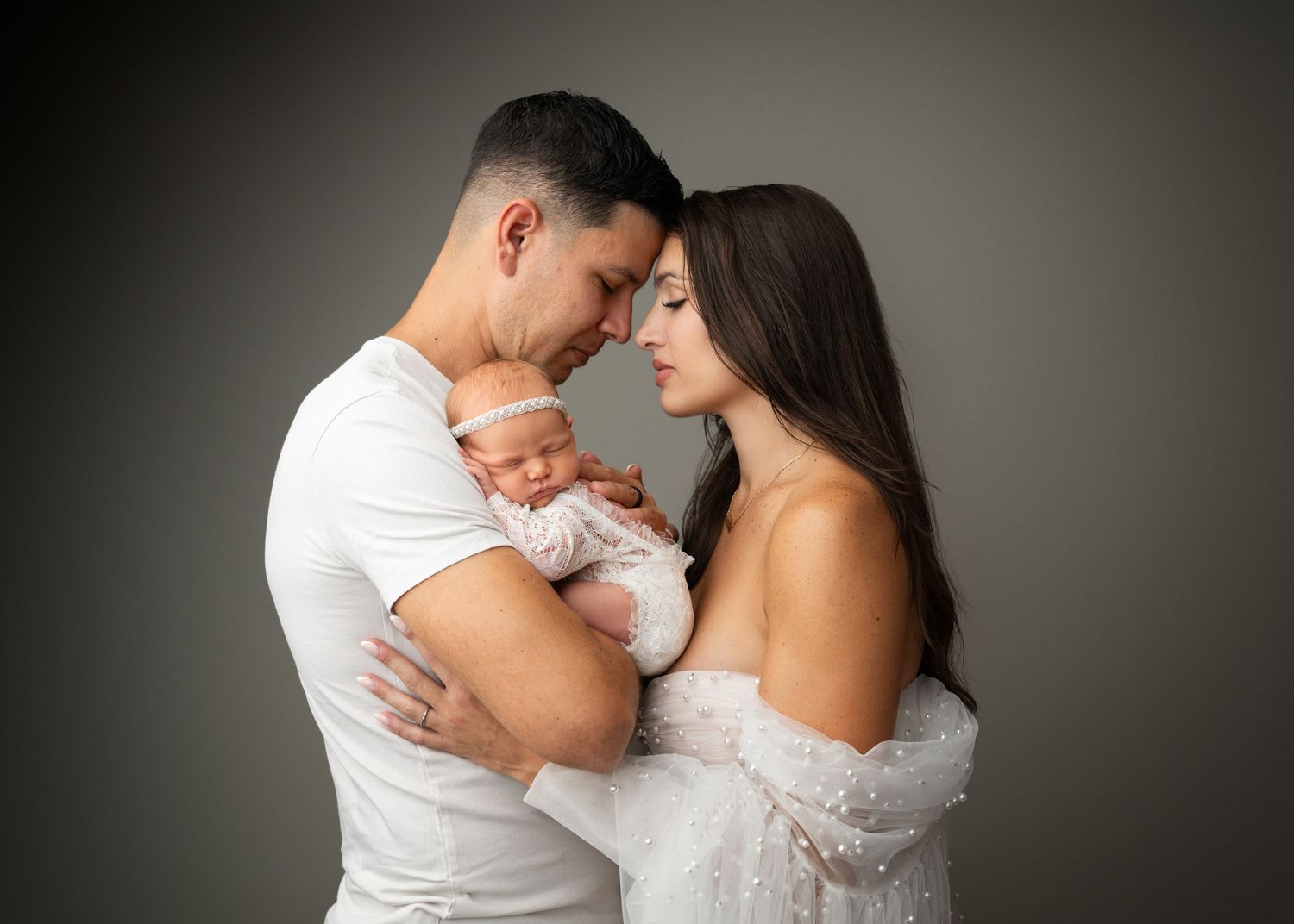 Parents holding their newborn baby during a studio newborn photography session in Linden, New Jersey.