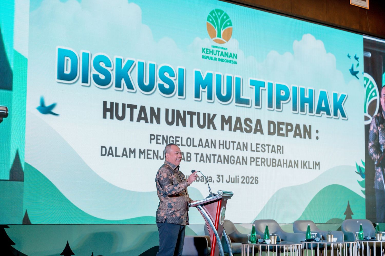 Man speaking at Diskusi Multipihak forestry conference on sustainable forest management and climate change challenges in Indonesia.