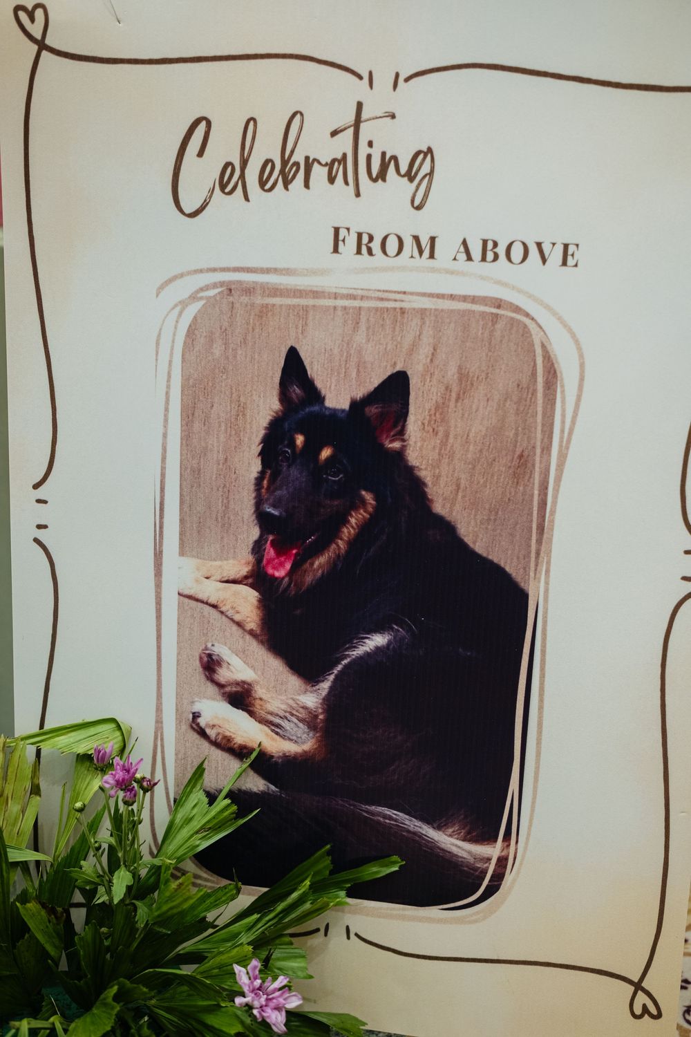 Memorial wedding sign reading Celebrating From Above featuring a German Shepherd dog photo with floral decorations.