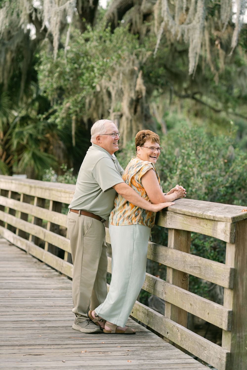 Anniversary portrait of a couple together on a wooden bridge beneath Spanish moss in south east georgia