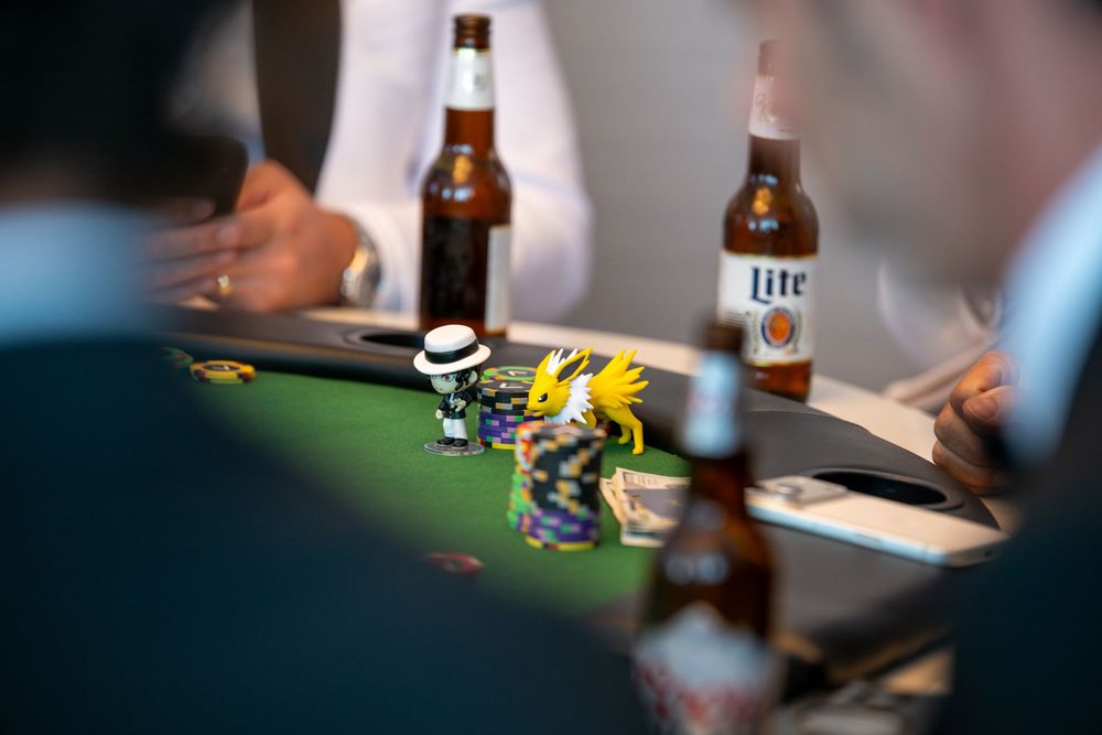 Poker table with chips, a toy figure, and Miller Lite beer bottles during a casual card game night.