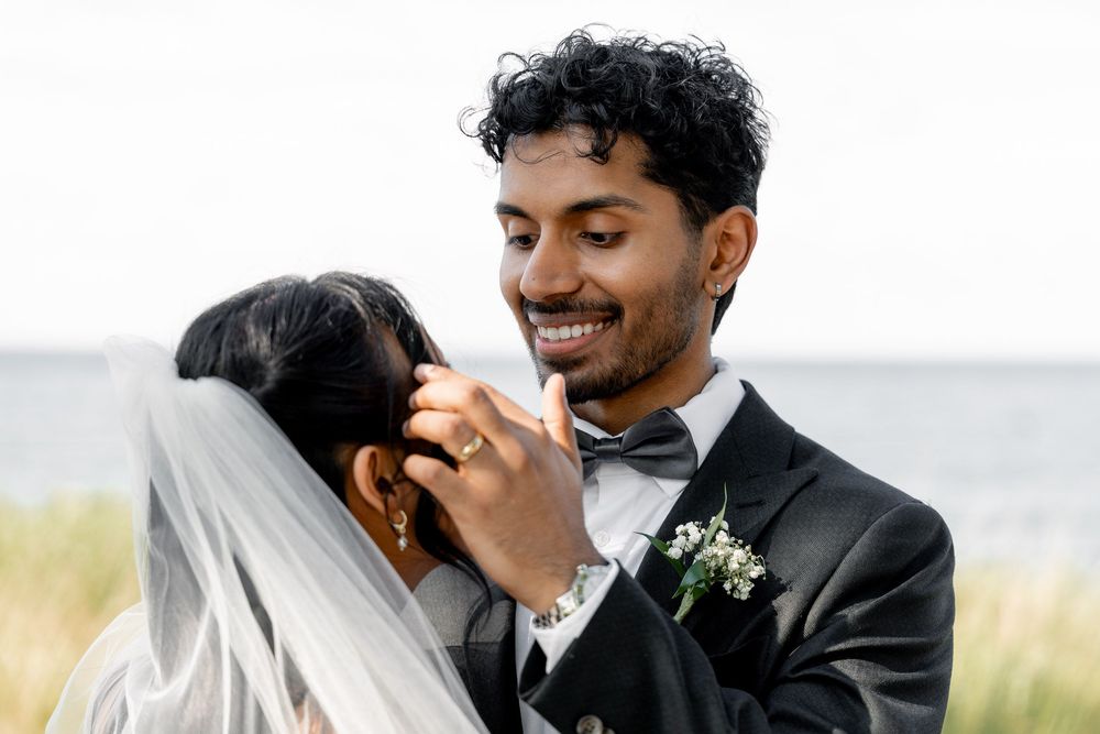 candid moment of the groom taking care of the bride
