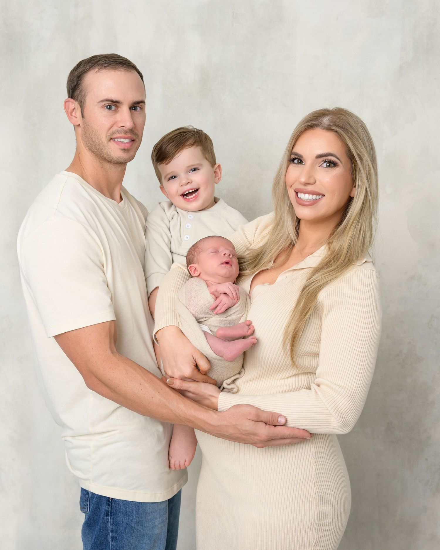 Parents with their newborn baby and older brother during a family newborn photography session in Zephyrhills, Florida.