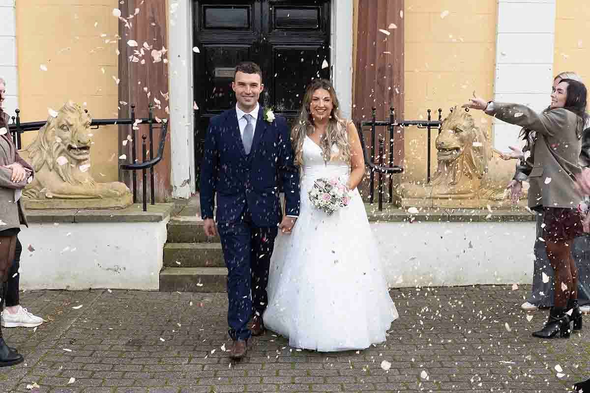 Newly wed couple celebrate outside Cockermouth town hall as guests throw confetti on thier wedding day.