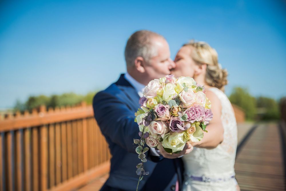 Brudepar krammer på bro – bryllupsfoto af Martin & Louise