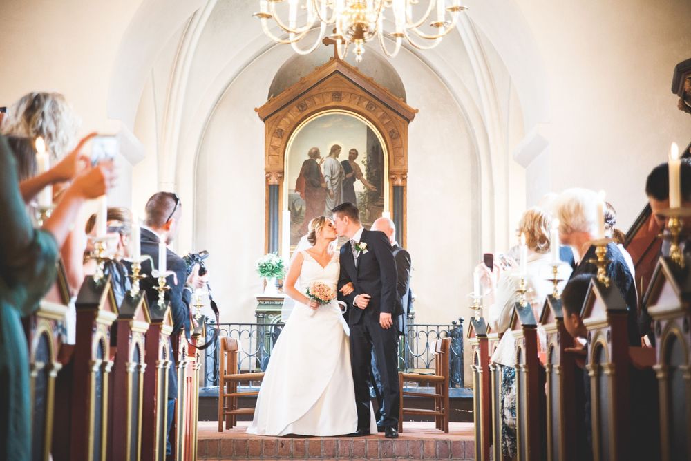 Brudepar i kirken under vielsen – bryllupsfoto af Martin & Louise